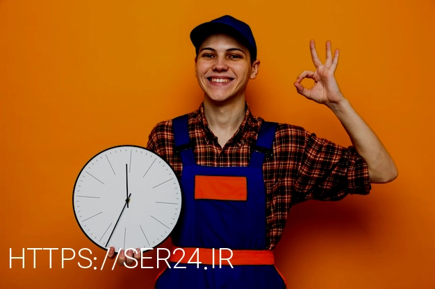 Free photo smiling showing okay gesture young cleaning guy wearing uniform and cap holding wall clock